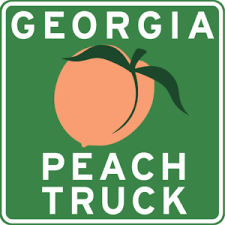 Logo for Georgia Peach Truck- it's a road sign looking square with a peach in the middle and white text.