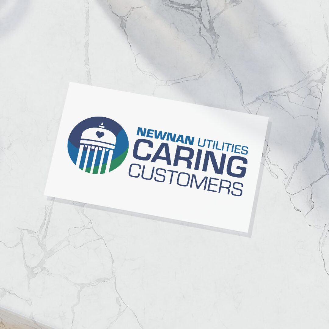 A mockup of a card with the Caring Customers logo on a marble table